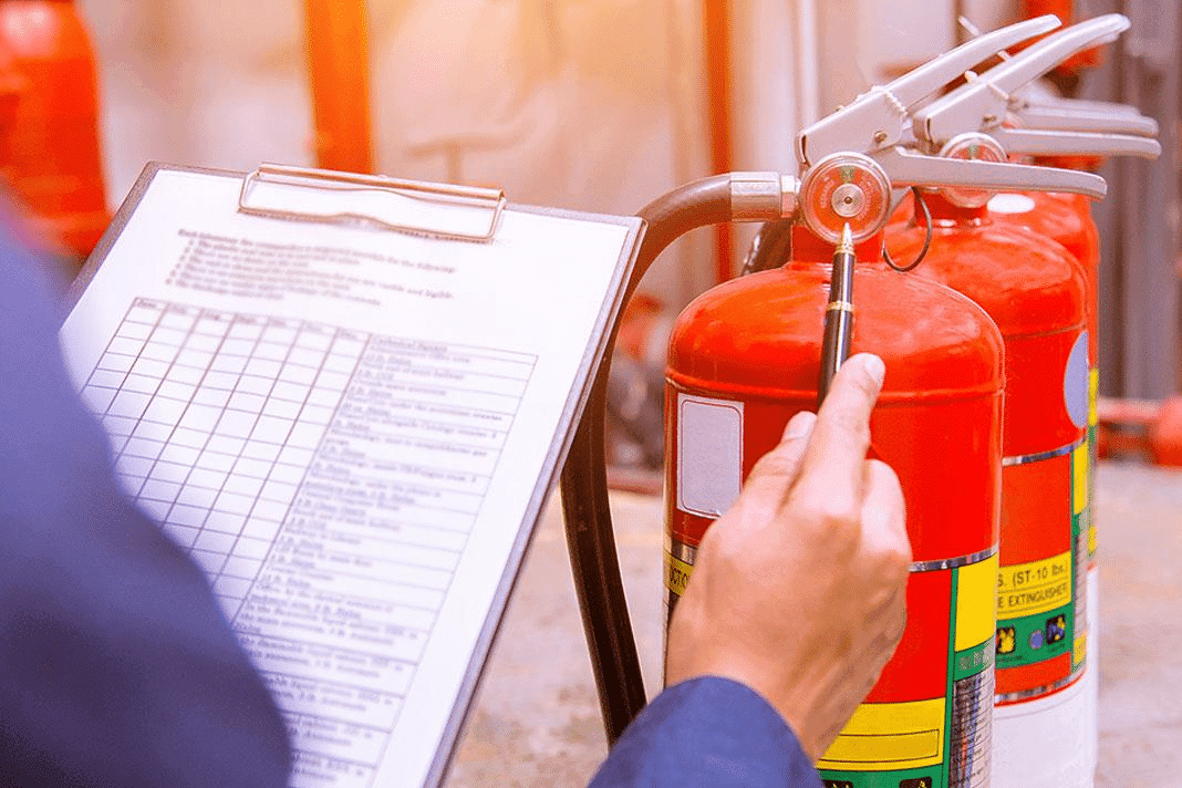 Extintor de incêndio sinalizado em corredor de empresa — itens verificados na vistoria do Corpo de Bombeiros do Paraná